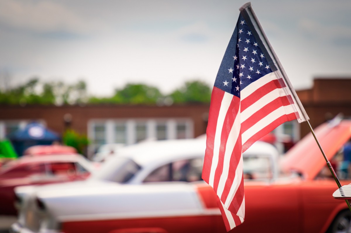 classic car in the background of a flag